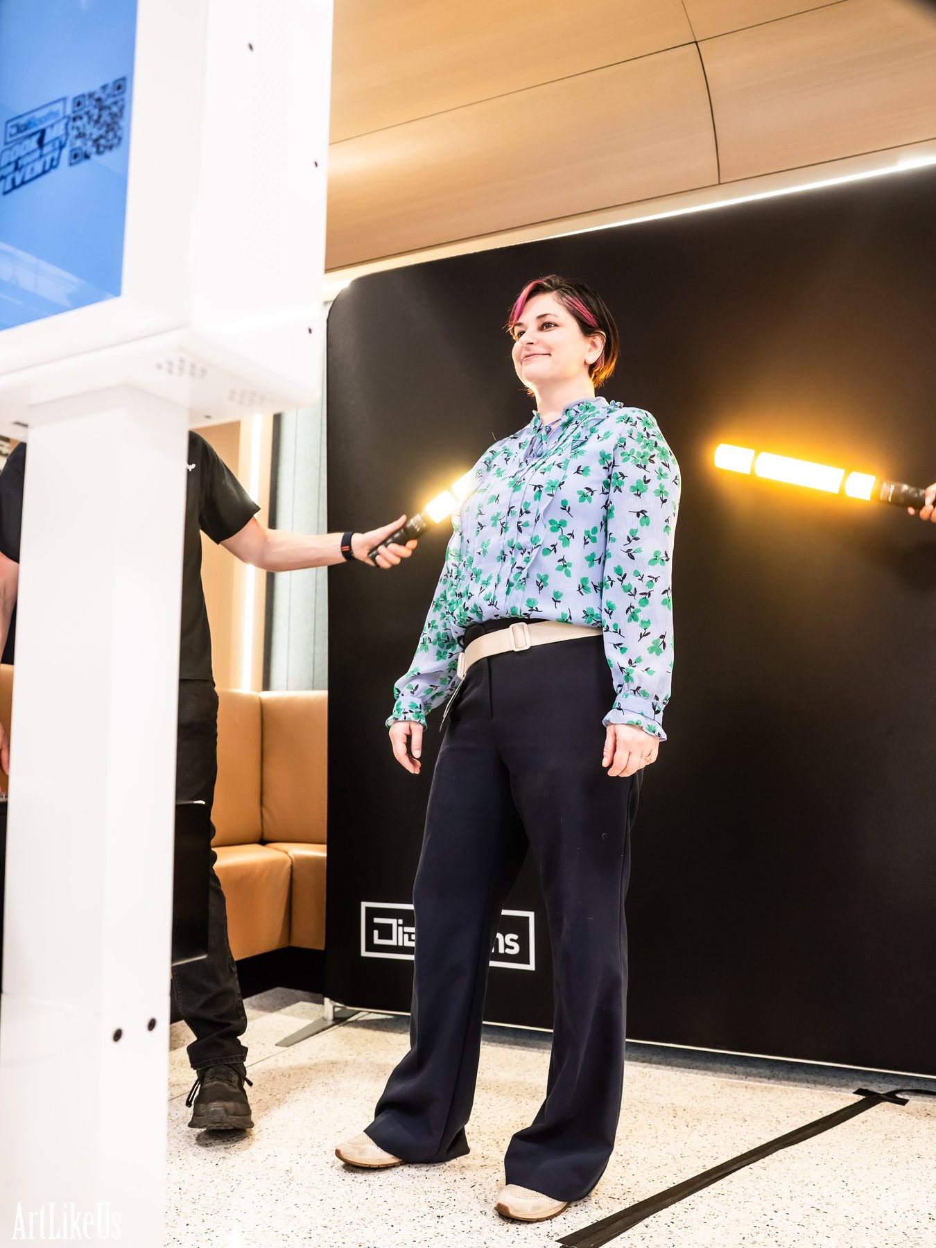 A guest posing at the DigiBooths light painting backdrop as an orange LED wand streak sweeps past