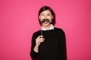 Woman holding mustache prop showing photo booth rental cost value at event.