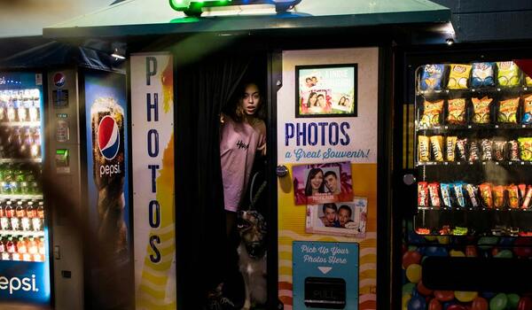 Woman using indoor photo booth rental service at entertainment venue.