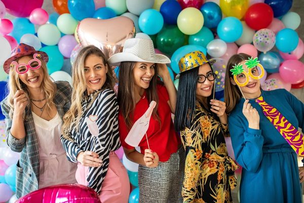 People posing with photo booth accessories