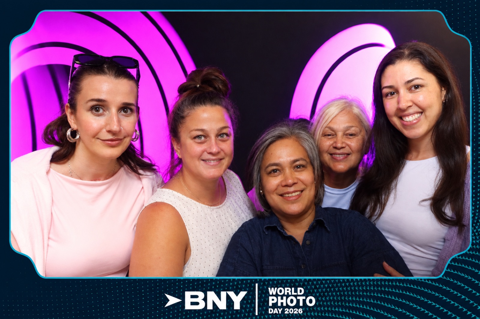 Finished light painting photo booth print — five guests framed by glowing magenta and pink long-exposure light arcs