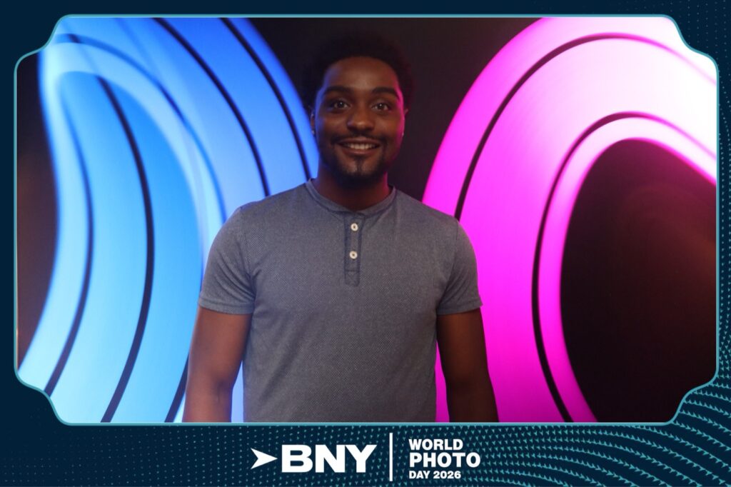 Finished light painting photo booth portrait — a guest framed by symmetric blue and pink long-exposure light arcs